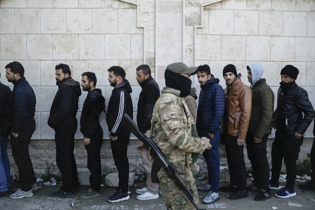 Former soldiers of the Assad regime's army queue for registration at one of the reconciliation points in Latakia.