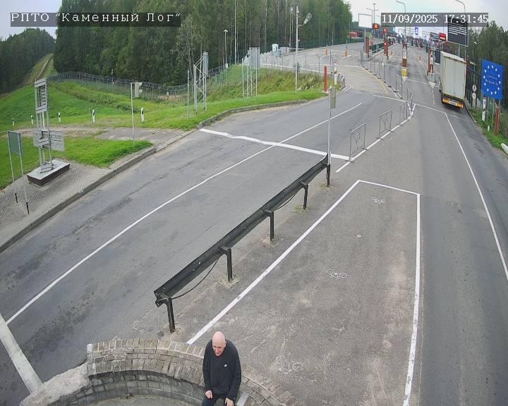 Mikola Statkevich in the "neutral zone" between the state borders of Belarus and Lithuania. The entry point to the latter, marked by a sign with an EU flag, can be seen in the background.