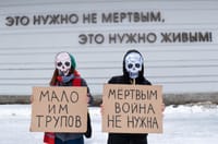 (In the background) "The dead do not need this. The living do." (Signs) "Too few corpses." "The dead don't need war."