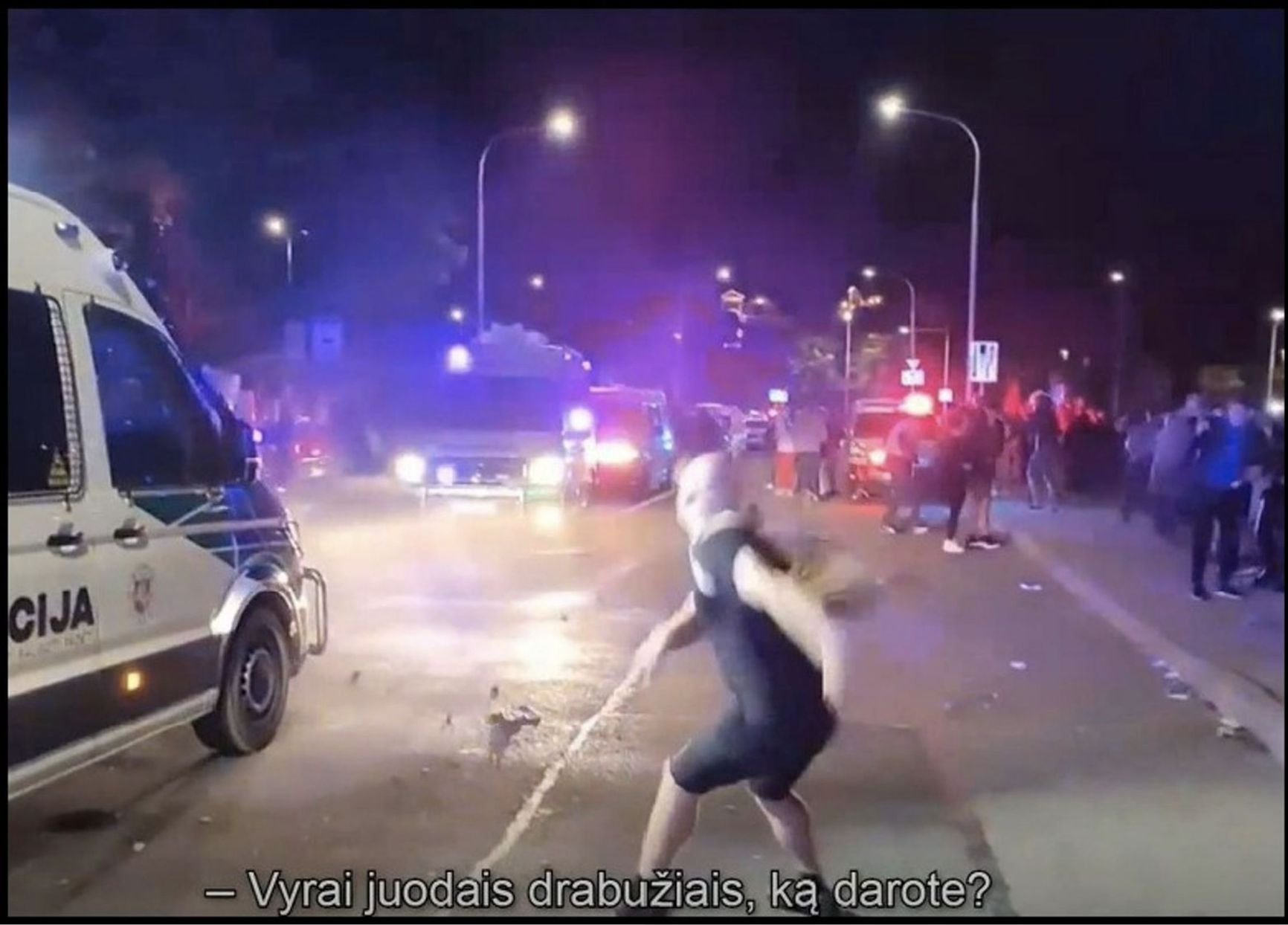 Artur Tochilov, a supporter of Paleckis, throws stones at police officers at a rally 