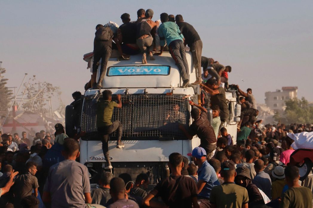 Palestinians stop a truck carrying unified humanitarian aid entering the southern Gaza humanitarian corridor near Rafah