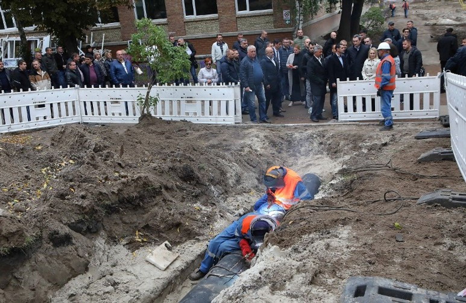 Workers in Kyiv repairing central heating pipes